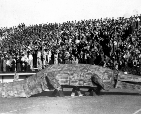Students march in a large wooden alligator