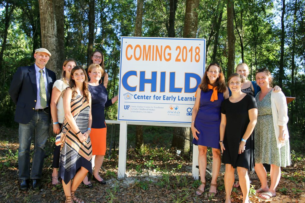 Members of the Anita Zucker Center standing in front of a sign for the Child Center for Early Learning.