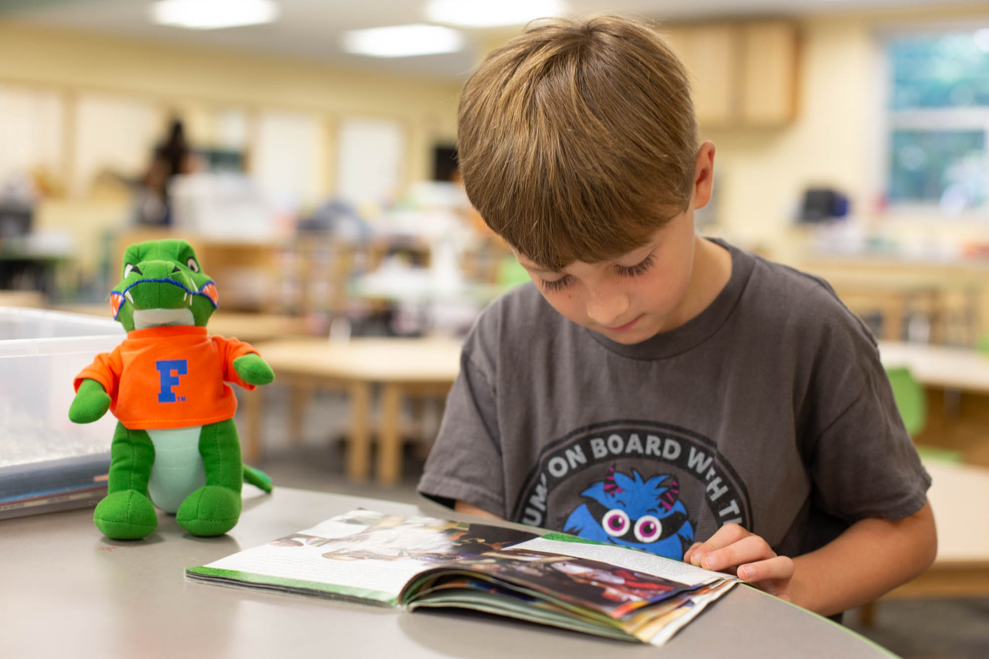 Young Student Reading with Albert Gator