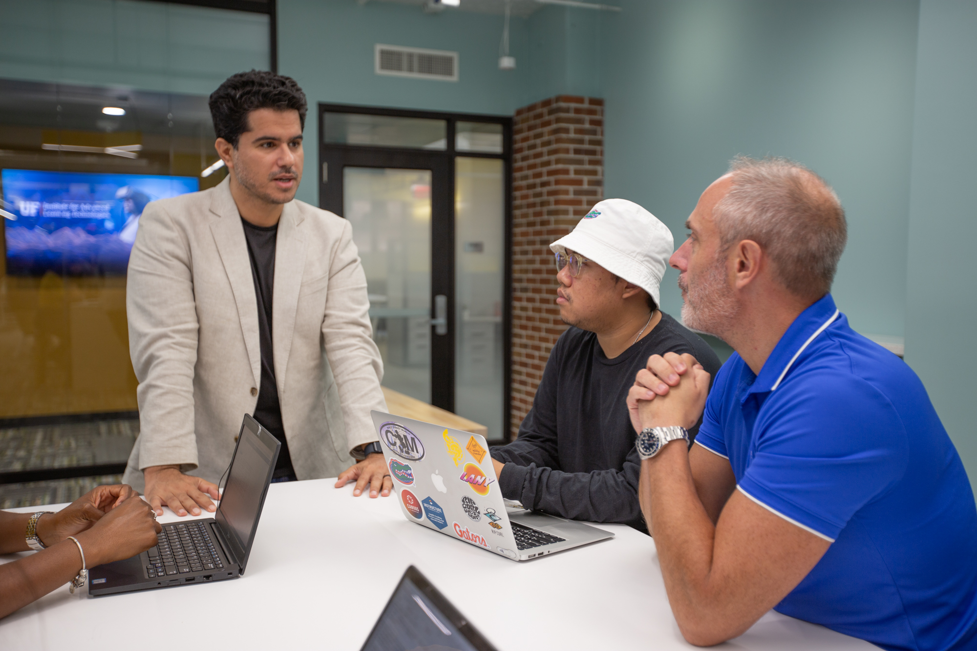 Seyedahmad Rahimi, Ph.D., a UF ed tech graduate student and Nigel Newbutt, Ph.D., sit in the IALT area of Norman Hall, discussing educational technology jobs following degree completion.