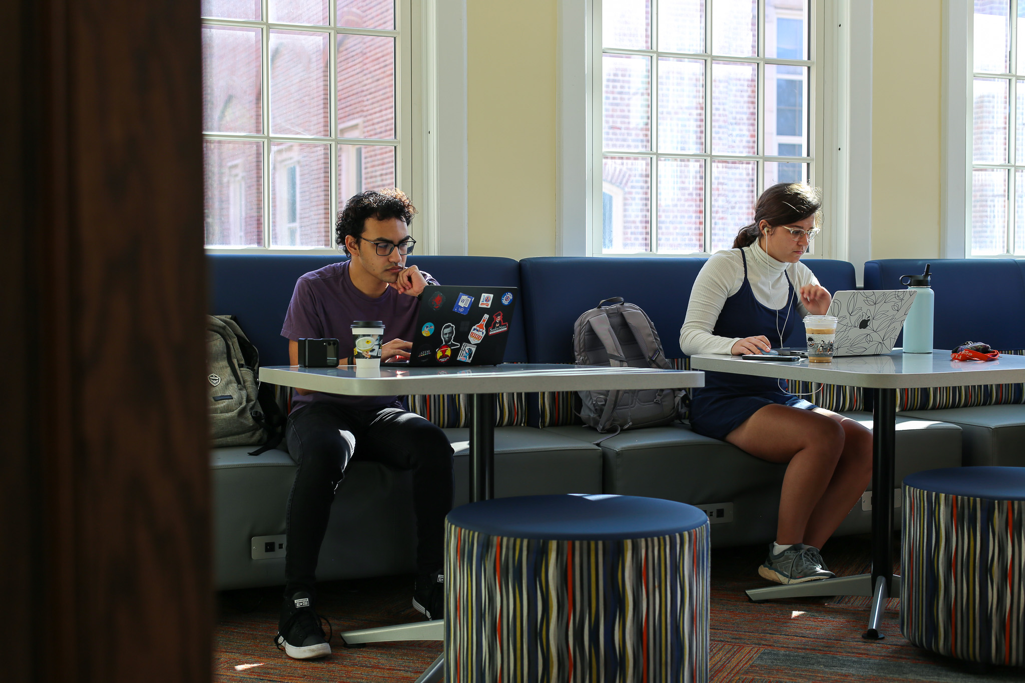 2 students using their laptop in the common space