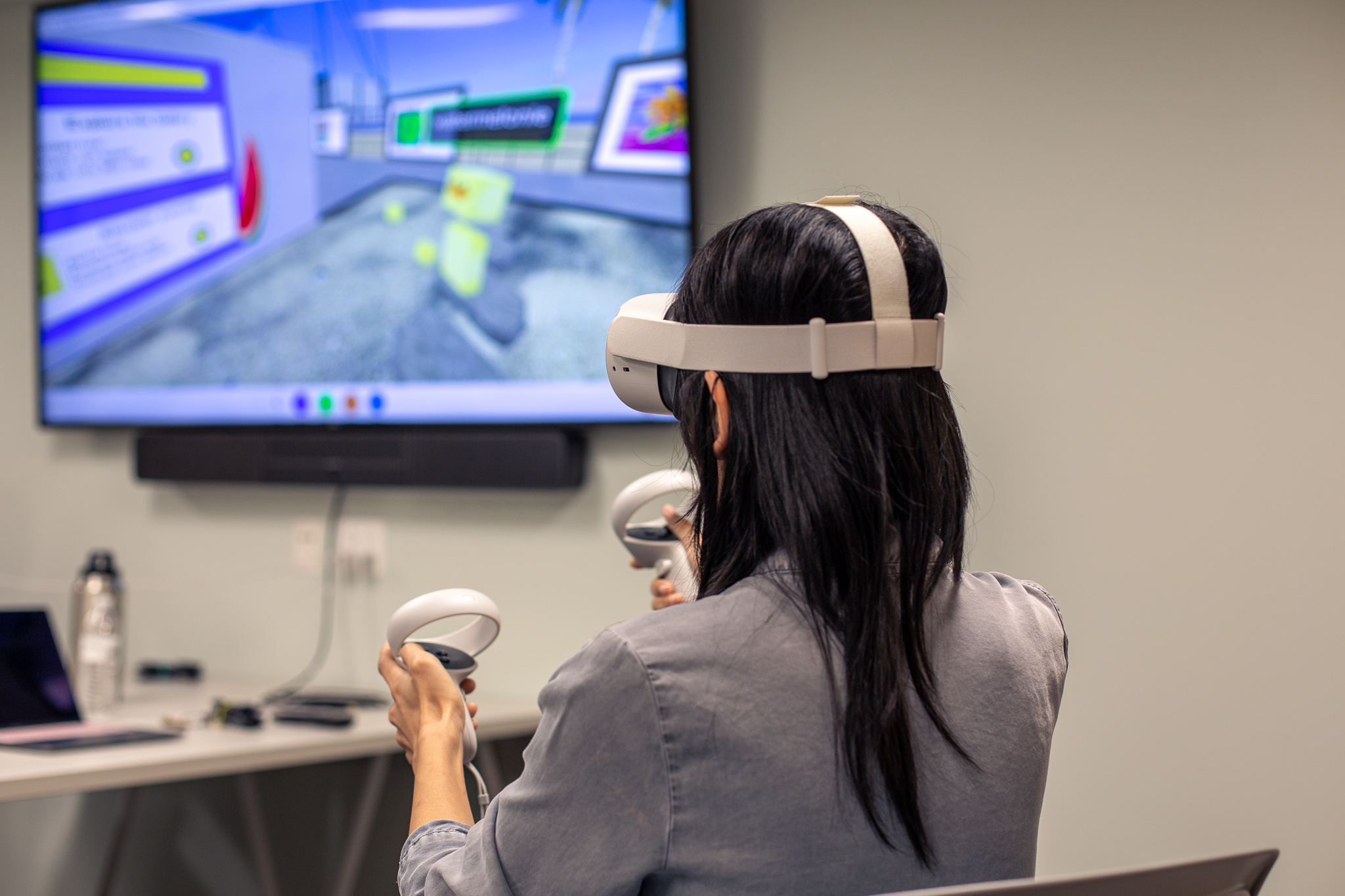 A woman using a VR headset in a classroom.