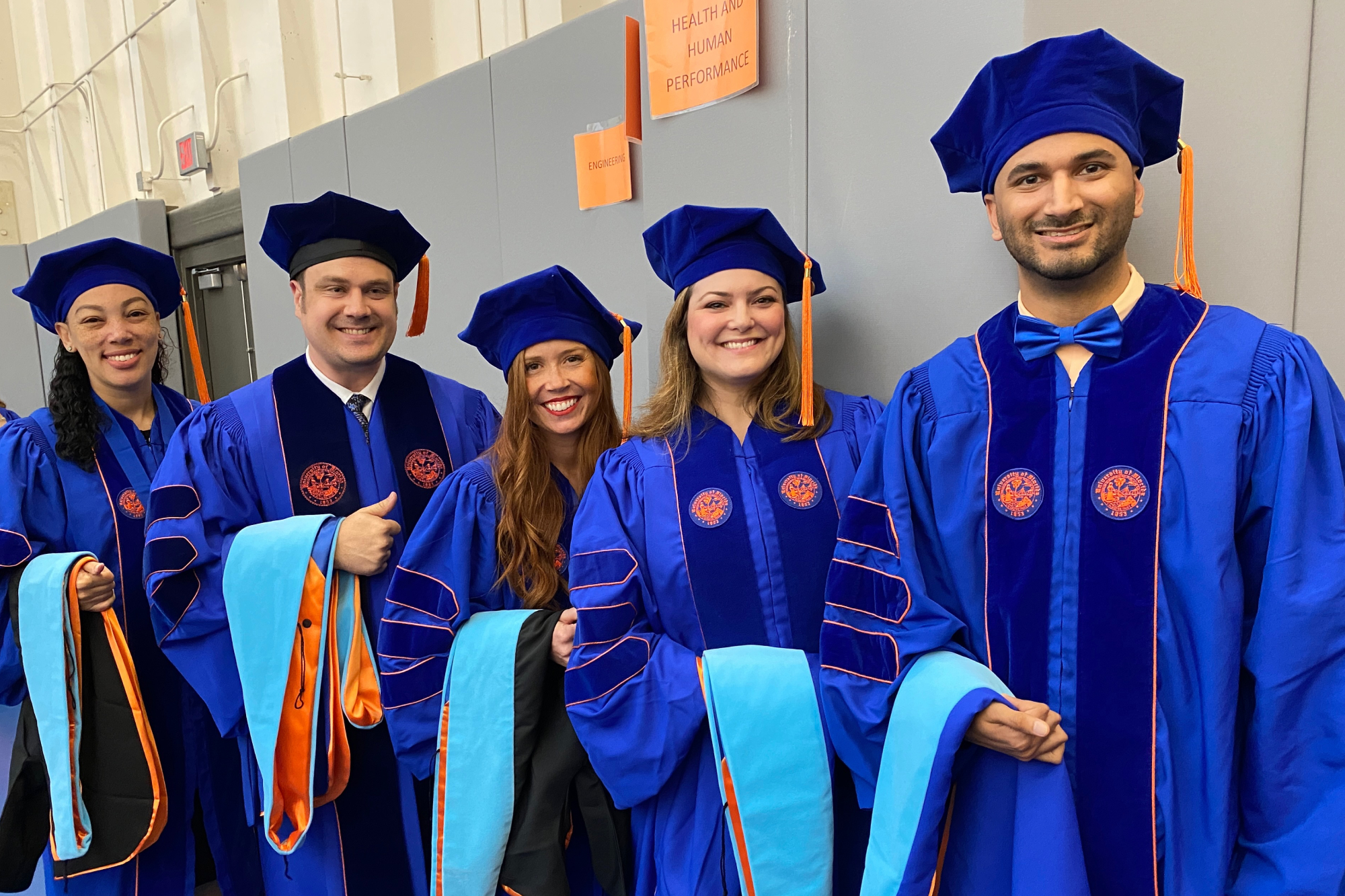 Four people looking at an iPad together and smiling.
