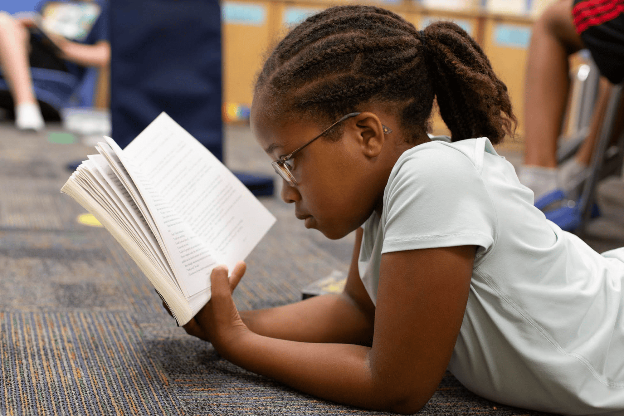 young kid reading. book on the floor