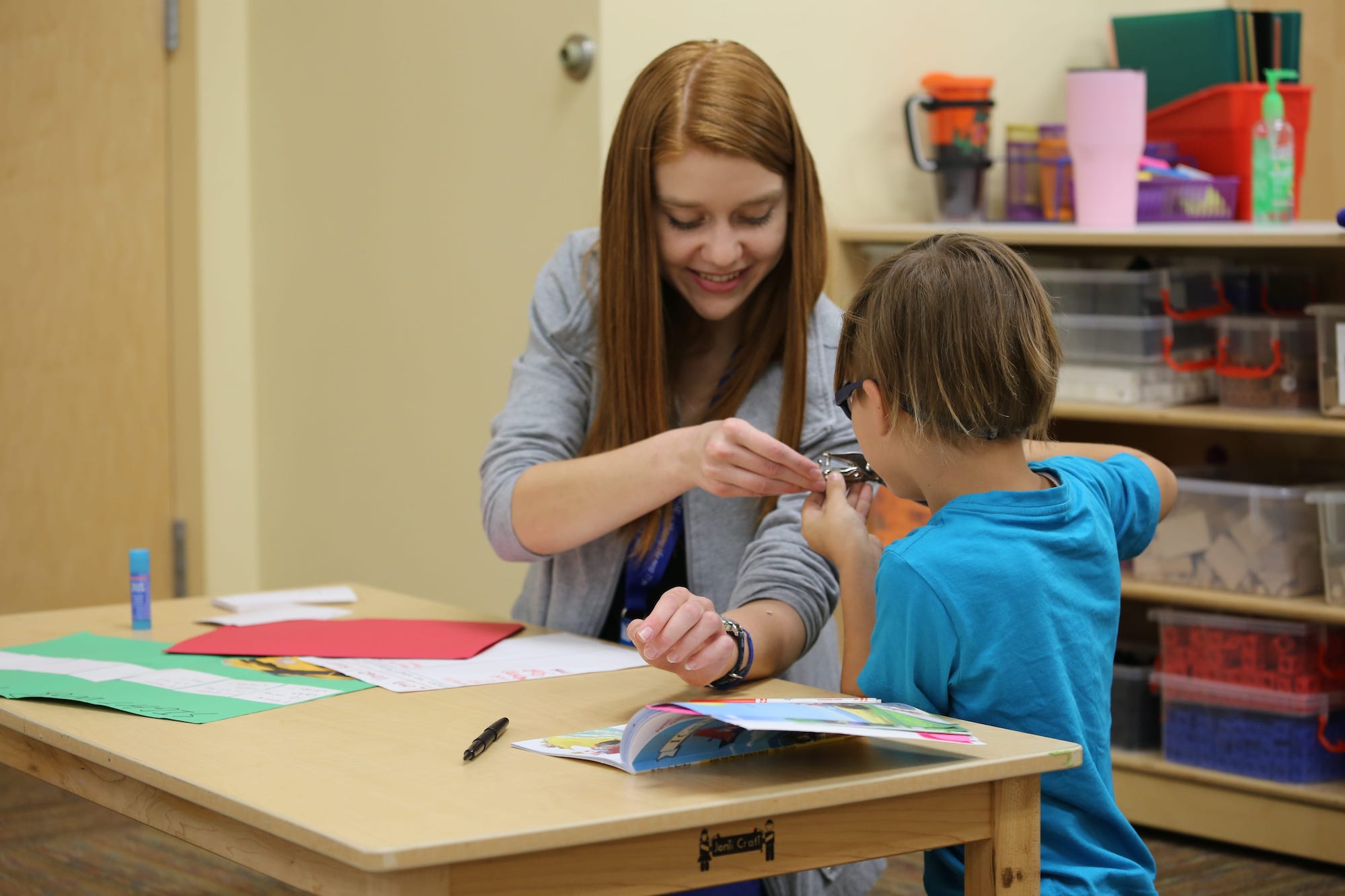 A member of UFLI interacting with a kid in a classroom