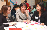 UF doctoral education student Angela Gregory, left, and Professor Danling Fu discuss with student-intern Ting Tseng a recent session with Newberry Elementary fifth-graders.