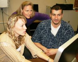 John Giddo and Kirsten Brooks (left) work in UF's computer lab with instructor Kara Dawson looking on. 