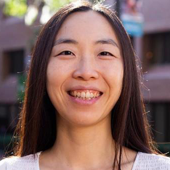 Headshot of Hyunyi Jung. She is wearing a white shirt and smiling in the Norman Courtyard