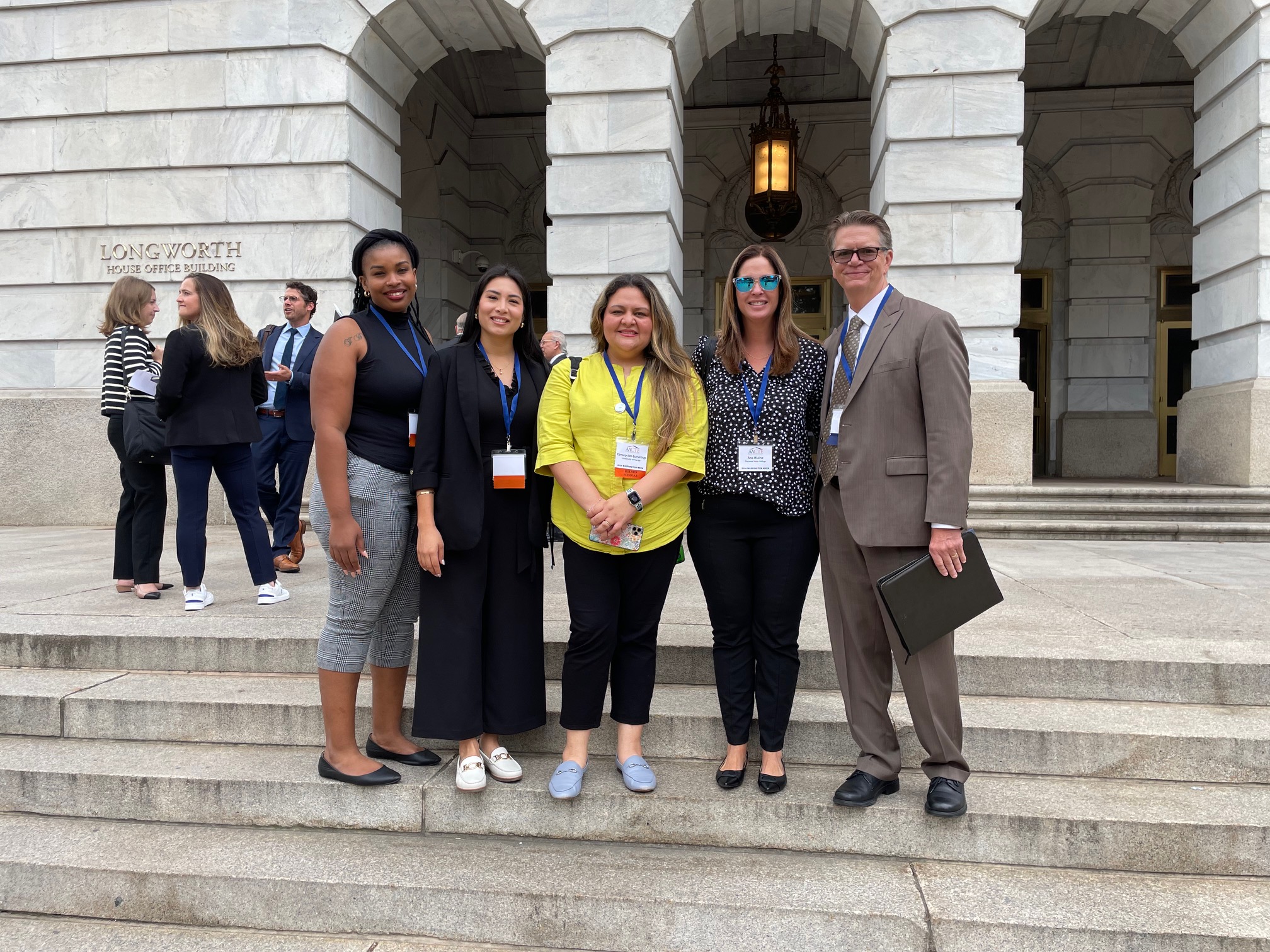 Four women and a man posing on the steps of Capitol Hill