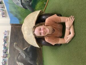 Kelsly Chatraw posing underneath a turtle shell statue.